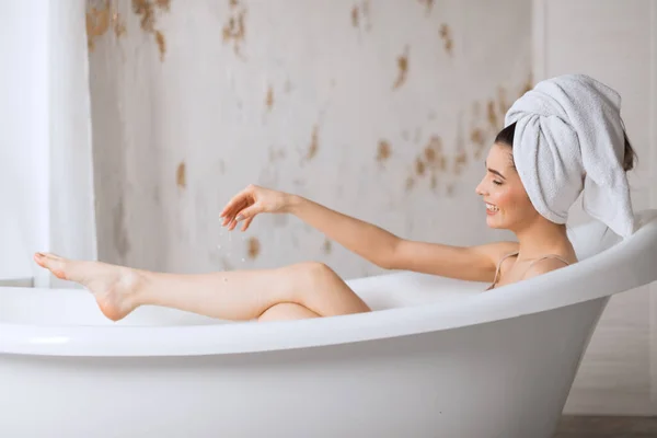 Розслаблена молода жінка лежить у ванній — стокове фото