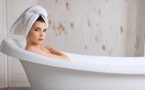 Relajada joven mujer acostada en la bañera —  Fotos de Stock