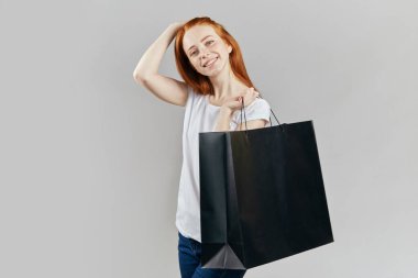 Çekici kızıl saçlı kız kameraya bakıyor.