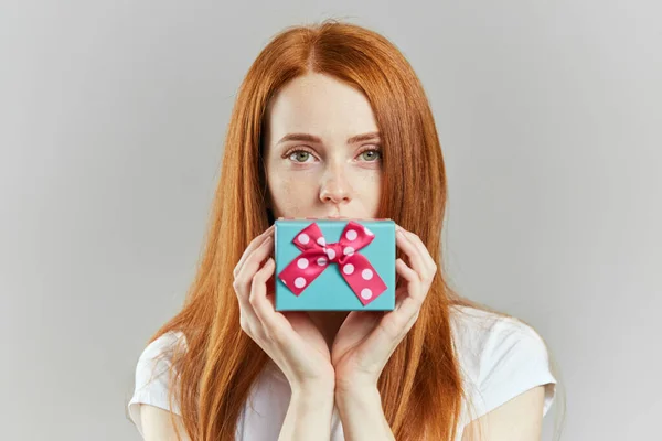 Mujer agradable con hermosos ojos verdes sosteniendo pequeña caja de regalo azul. . —  Fotos de Stock