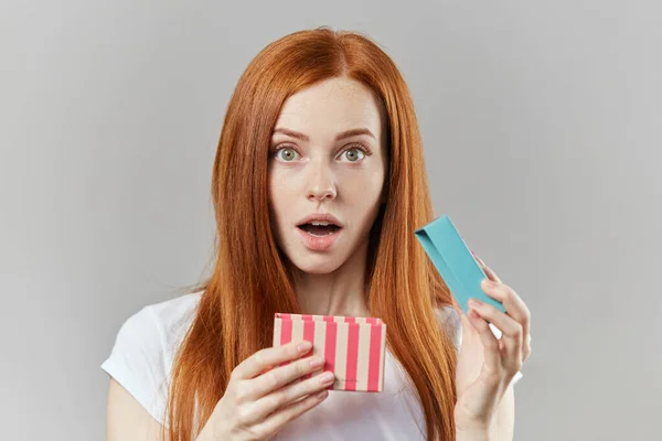 Chica sorprendida sosteniendo abierto caja de regalo y loking en la cámara — Foto de Stock