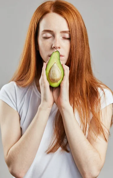 Agradable impresionante mujer cubriendo su boca con aguacate —  Fotos de Stock