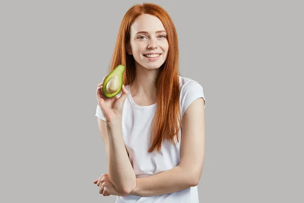 Feliz hermosa chica jengibre sosteniendo una fruta —  Fotos de Stock