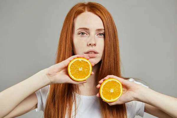 Chica guapa mostrando naranjas a la cámara — Foto de Stock