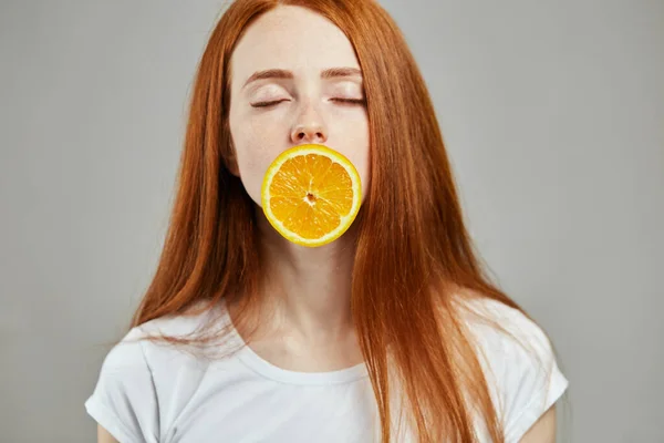 Hermosa cara de mujer con naranja. primer plano foto — Foto de Stock