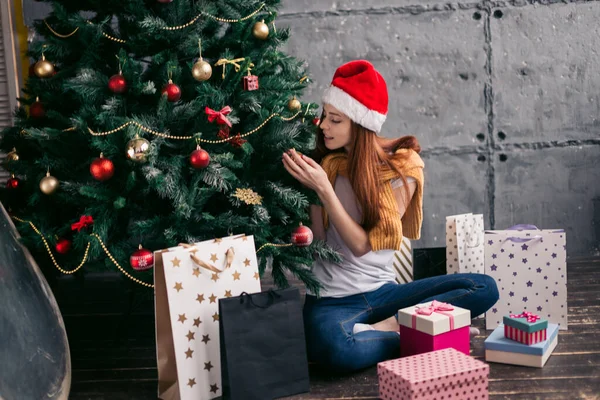 Attraente ragazza dai capelli rossi decorare l'albero di Capodanno — Foto Stock