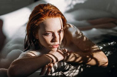 Genç, baştan çıkarıcı, seksi, kızıl saçlı, işbirliği yapan, banyo yapan bir kadın..