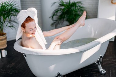 Ba Beauty 'nin uzun, mükemmel bacakları içinde banyo yapan bir kızın ince bacakları. Yasaklama kavramı.