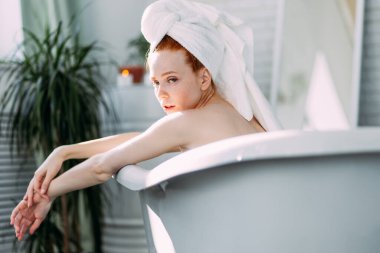 Genç, baştan çıkarıcı, seksi, kızıl saçlı, işbirliği yapan, banyo yapan bir kadın..