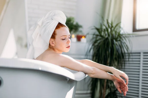 섹시하고 예쁜 빨간 머리 여자가 욕조에서 머리를 하고 있어. — 스톡 사진