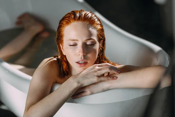 Bella seducente giovane signora dai capelli rossi con spalle nude nella vasca da bagno. — Foto Stock