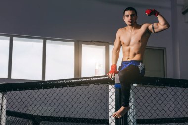 Kickbox profesyonel dövüşçüsü çıplak kaslı gövdesi kameraya poz veriyor..