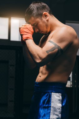 Erkek boksör konsantre oluyor, yumruklarını ön plana koyuyor, büyük dövüşe hazır.