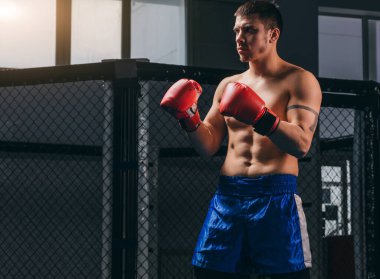 Kickboksör ringin ortasında duruyor ve rakibine meydan okuyor..