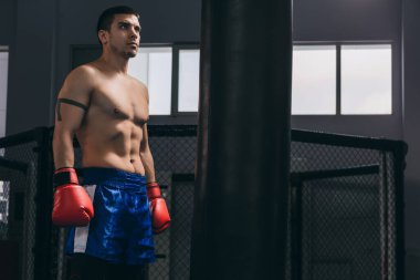 Kickboksör ringin ortasında duruyor ve rakibine meydan okuyor..