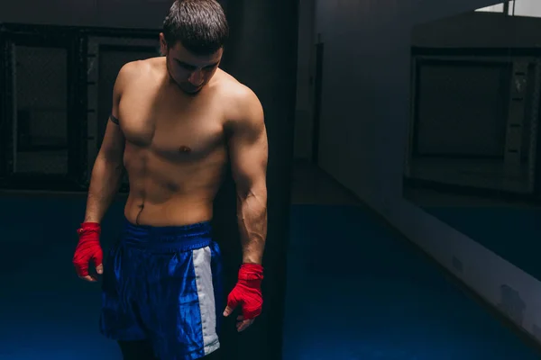 Kickbox professionell fighter med naken muskulös bål poserar för en kamera. — Stockfoto