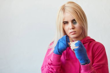 Pembe kapüşonlu ve boks bandajlı kadın boksör..