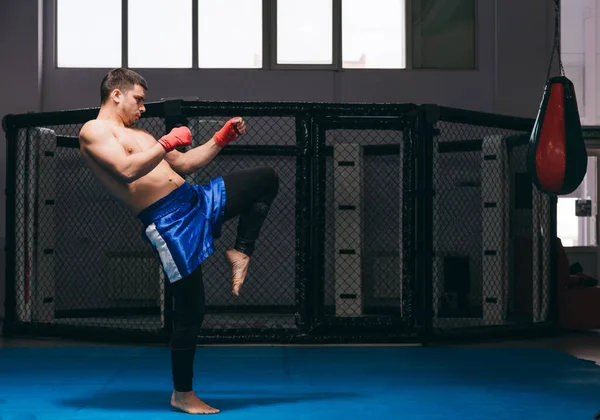 Boxer a l'air fort et puissant, pratique coups de pied, se réchauffe avant le jeu intérieur — Photo