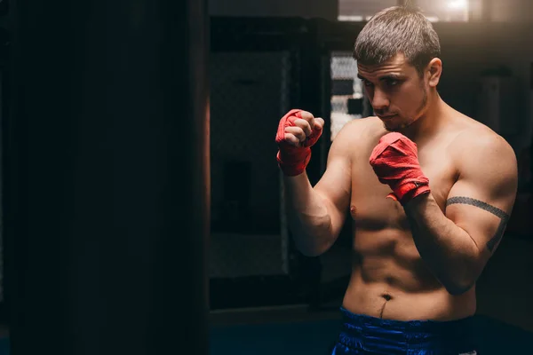 Lutador de batalha misto em posição de combate, contra um fundo escuro centro. — Fotografia de Stock