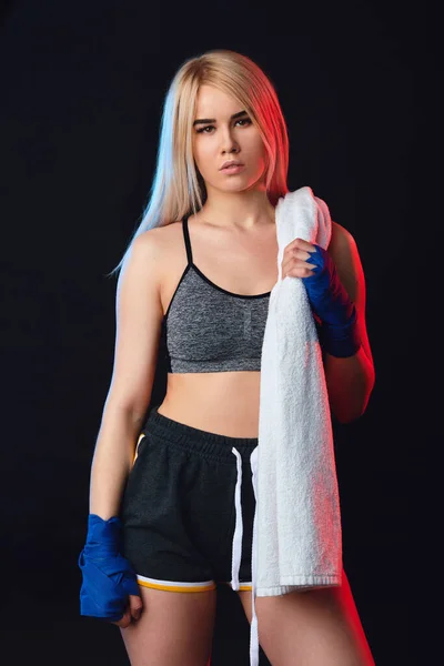 Sportieve blonde vrouw kickboxer vechter met witte handdoek op de hals na de training. — Stockfoto