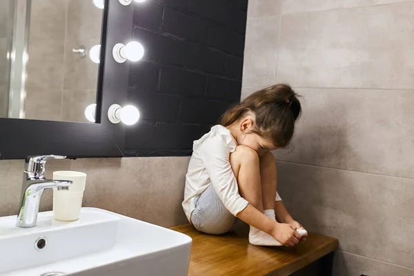 Criança encantadora sentada no banheiro — Fotografia de Stock