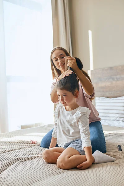 Giovane madre pettinando bambino — Foto Stock