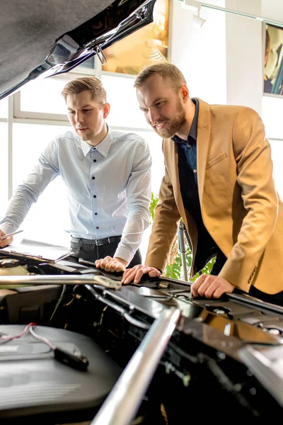 Vendedor de coches mostrar la capucha de montaje perfecto del coche — Foto de Stock