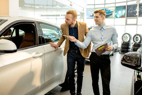 Vendedor de coches hablar de las ventajas de coche —  Fotos de Stock