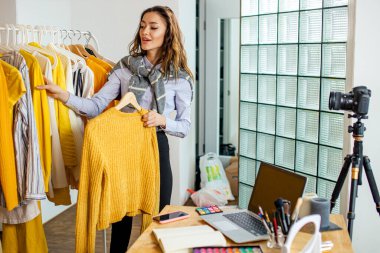 Güzel, sevimli bayan blogcu karşılaştırın ve yeni giysiler gösterin