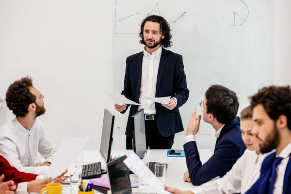 good-looking smiling manager with colleagues in office