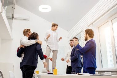 Genç iş adamları ofiste kutlama yapıyorlar.