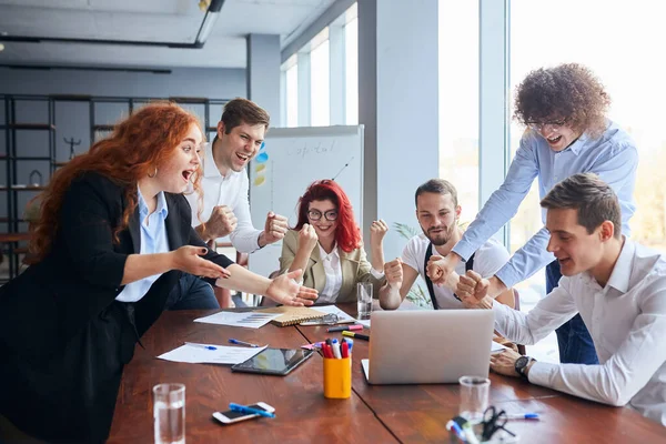 Glada affärsmän samlades runt bordet på kontoret — Stockfoto