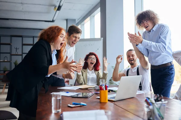 Feliz positivo alegre equipe de negócios comemorar a vitória na mesa — Fotografia de Stock