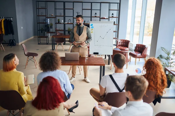 Giovane uomo d'affari team leader allenatore mentore parlare con diversi uomini d'affari in ufficio moderno — Foto Stock