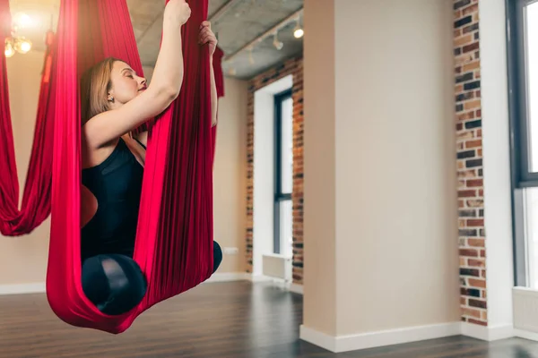 Fit yogini female diversifies her workouts performing antigravity yoga exercises — Stock Photo, Image