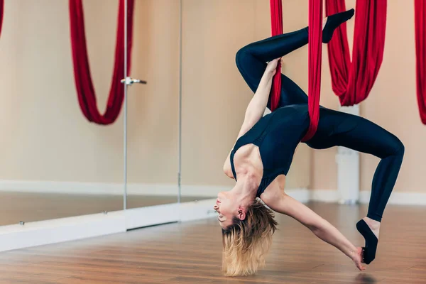 Fit Yogini-Hündin diversifiziert ihr Training mit Antigravitations-Yoga-Übungen — Stockfoto