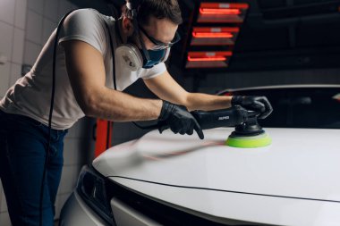 Genç adam elektrikli araba cilalayıcısını test ediyor.