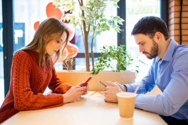 Kafkasyalı genç çift cep telefonuna daldı.