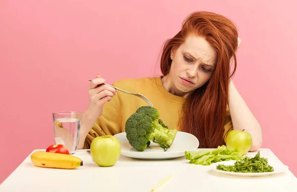 Pflanzliche Ernährung. Traurige langweilige Frau hält Brokkoli auf Gabel und macht Fratze — Stockfoto