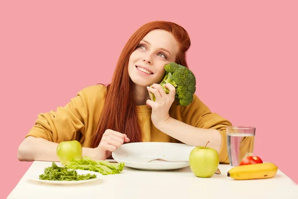 Slim donna felice si siede a tavola con sogni di broccoli su torta saporita, tentazione — Foto Stock