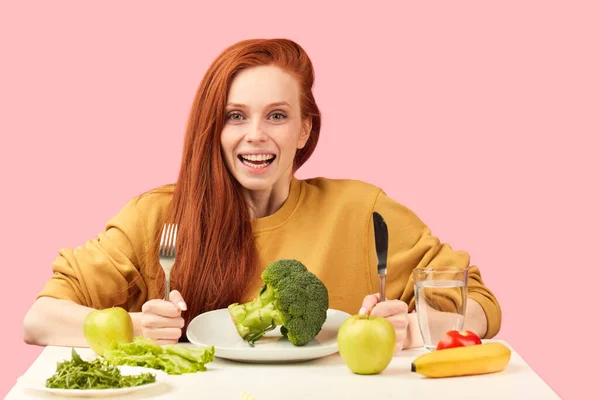 Bella rossa donna caucasica seduta a tavola con cibo sano e broccoli — Foto Stock