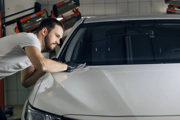 Homem atraente pensativo aprendendo a polir o auto — Fotografia de Stock