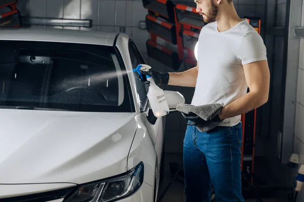 Attraktive Arbeiterin putzt Autoscheibe in der Garage — Stockfoto