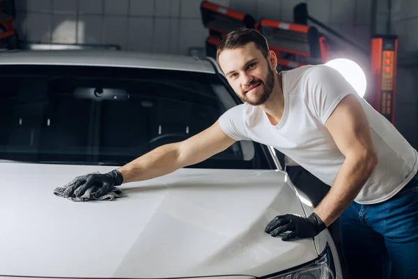 Positif beau mécanicien nettoyage de la surface de sa voiture — Photo