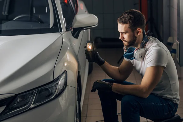 Homme sérieux concentré sur le contrôle de la peinture du véhicule — Photo