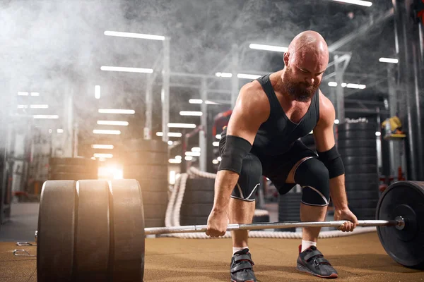Hårlös powerlifter bodybuilding i garage — Stockfoto