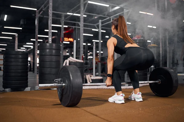 Mulher no ginásio fazendo exercícios com barra — Fotografia de Stock