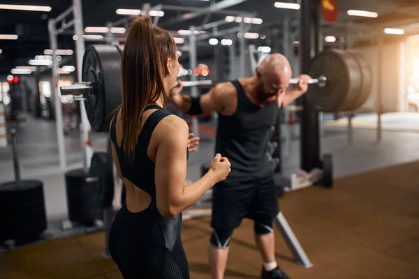 Brutale man met beutiful trainer in de sportschool — Stockfoto