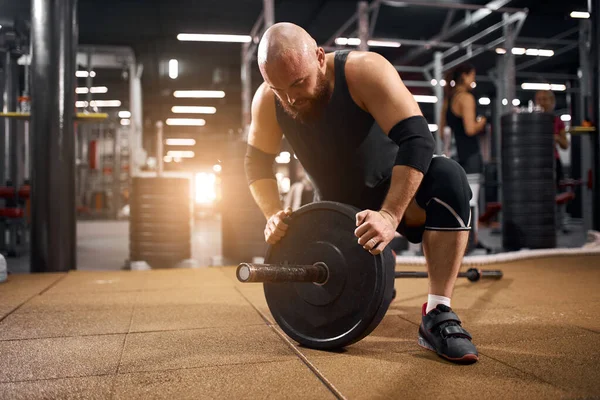 Powerlifter byta järn skivor i gymmet — Stockfoto