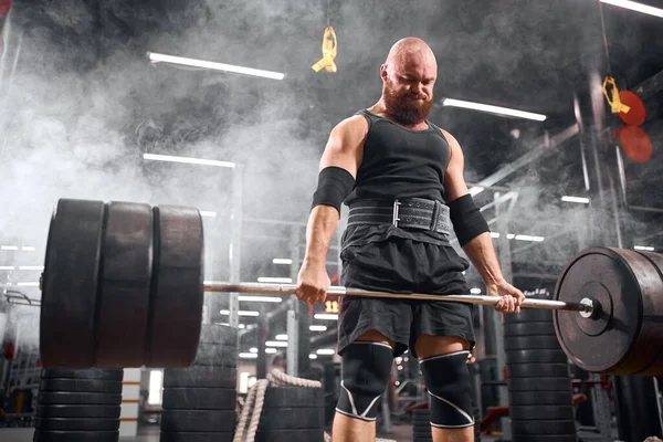 Hårlös powerlifter bodybuilding i garage — Stockfoto